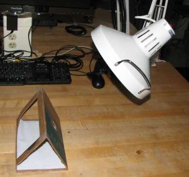 floor (see Figure 2). Attach a flashlight to a ring stand and place it approximately 24" from the structure (Figure 3). Figure 3: Folded solar structure with light Questions: 1.