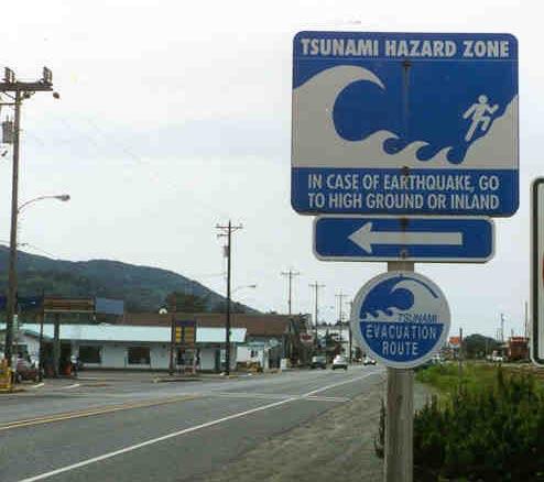 6.0 EXAMPLES OF PROPER PLACEMENT OF HAZARD ZONE SIGN AND EVACUATION ROUTE SIGNS Rockaway Beach: Hazard zone and evacuation route signs at the corner of Hwy 101 and 3rd Avenue.