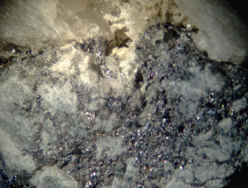 Figure 3. Gold-bearing, fine-grained galena in vuggy quartz vein with minor calcite. DDH R-11 at 80.4. Horizontal field of view is 12.6 mm. Figs. 3 and 4, from DDH R-11).