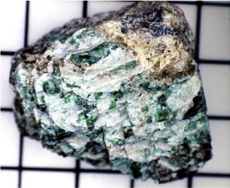 A chrome diopside is also nearly three centimeters in diameter but has cleavage planes filled with altered material.