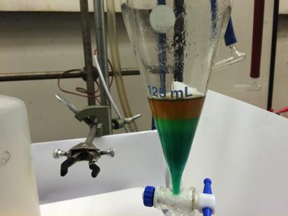 Two distinct layers are seen: -blue/green layer is aqueous -orange/brown layer is organic Crude product is