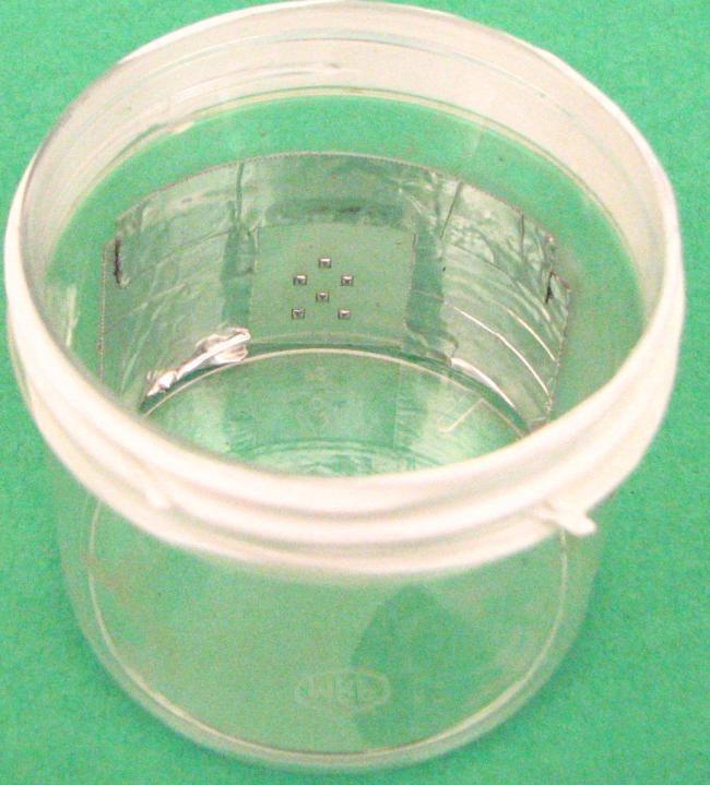 Figure 10: Laminate substrate constrained in the small plastic container before an assembly test. Using this method, some successful assemblies were made.