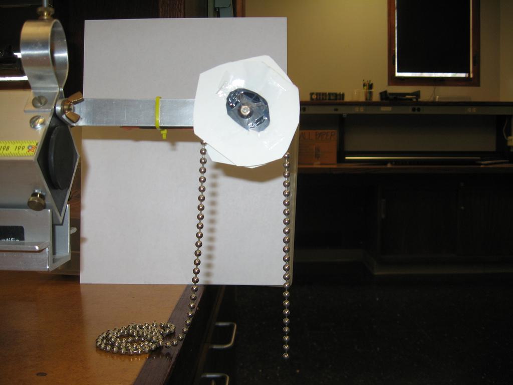 Figure 4: Experimental setup. The beaded chain is looped over the rotary encoder, which spins and directly records its movement.