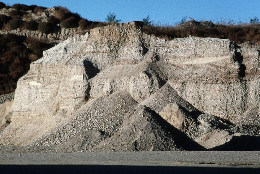 a) b) Figure 2: a) Neutron-derived porosity logs and the stratigraphy based on these logs at the BHRS. b) Photograph of a nearby gravel pit that is an analog to the BHRS.