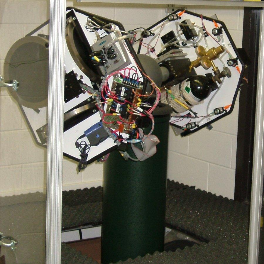 The two hardware-in-the-loop spacecraft simulators are individually mounted on spherical air bearing platforms, which provide a nearly torque-free environment for simulating attitude control.