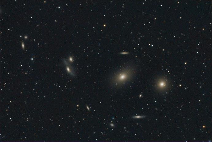 110 2 The Messier Objects Fig. 2.84 Photo of M84 ( right ) with M86 ( middle right ) along with several dimmer galaxies that are also part of the Markarian Chain.
