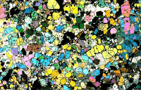 Thin section (~1 cm width) of a coarse-grained peridotite, seen without and with Nicol prisms. From Mackenzie and Adams: Rocks and Minerals, 1994.
