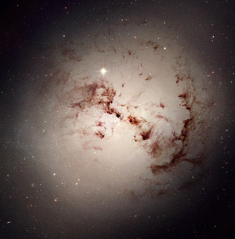 (a) (b) Figure 2.4: (a) NGC1316, an S0 galaxy showing dust lanes. This galaxy, also know as Fornax A, is a powerful source of radio emission (NASA/ESA Hubble Heritage Project).