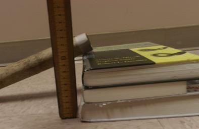 3. Lean a grooved ruler or paper towel tube against the textbooks (or other props) so that