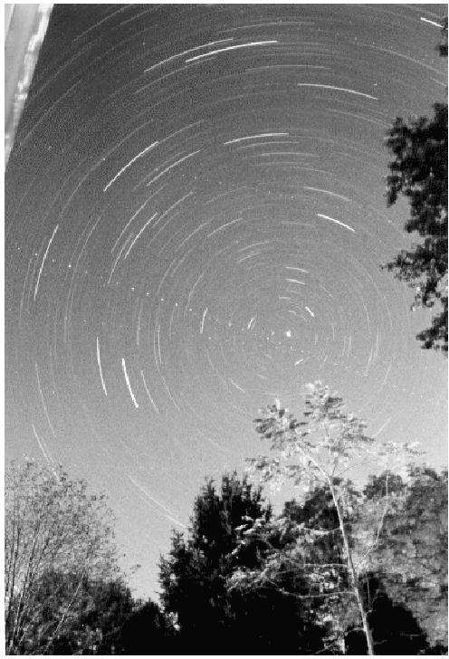 Figure 2.2: Pointing a camera to the North Star (Polaris, the bright dot near the center) and exposing for about one hour, the stars appear to move in little arcs.