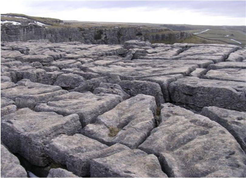 Name one surface karst feature evident in photograph A and explain, with the aid of a diagram, how this surface