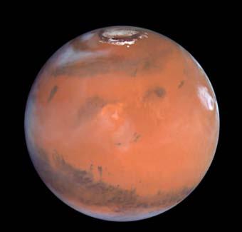 The next planet is Mars. It has a reddish color and a thin atmosphere. The red color is caused by rust in rocks. It is cold on Mars. The temperature sometimes drops to 87 C ( 125 F).