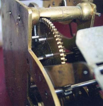 Clock is held in case by two machine screws, which are inserted from the outside of the back, pass through the two holes in the wood spacer, and enter the two holes shown in Figure 1I.