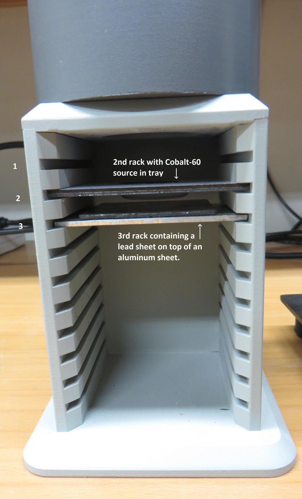 Figure 8: The source is kept on its tray on the second rack in the shelf. The lead sheet for enhanced backscattering is kept on an aluminum sheet which is kept on the third rack in the shelf. 1.