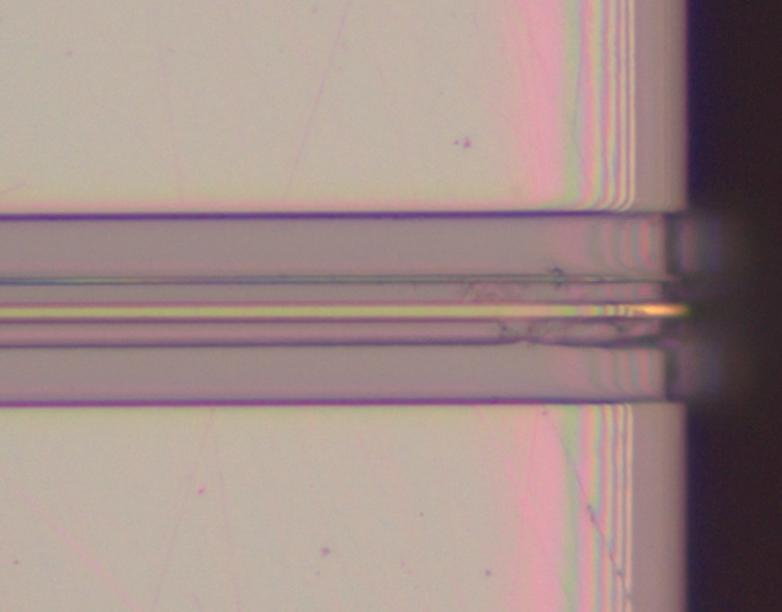 Right: Sample end face with light (λ = 633 nm) guided in the photonic wire (center) and in the remaining LN thin film on both sides. 4.