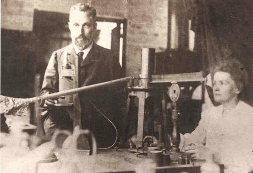 Marie Curie placing weights on piezoelectric