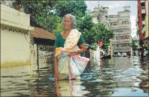 Floods in Bangladesh in 2004 Septuagenarian Tafurunnisa sloshes her way through stinky floodwaters in Dhaka on July 25