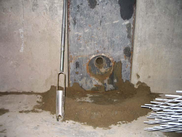 The borehole was advanced through a steel plate (bulkhead) bolted to the end of the pit opposite from the temporary concrete barrier.