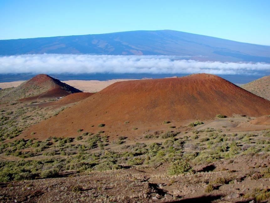 Shield Volcanoes (largest volcanoes) A shield volcano a mountain with broad, gently sloping straight sides, and a nearly circular base that forms when layer upon layer of basaltic lava accumulates