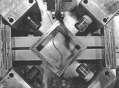 Four heavy steel blocks, rigidly connected to a base plate to prevent horizontal displacement, were used to hold both the jacks and the load cells.
