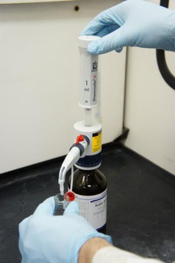 To use the dispenser, first confirm the red twist cap is off the nozzle (operating the dispenser with the cap on will pressurize the dispenser which may