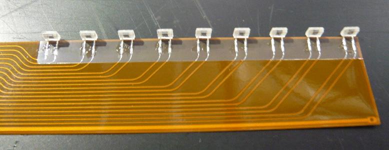 Figure 2: A layer aligned 72 scintillator strips hermetically enveloped in the reflector foil. Each strip has a hole on the reflector to introduce the LED light for the LED calibration.