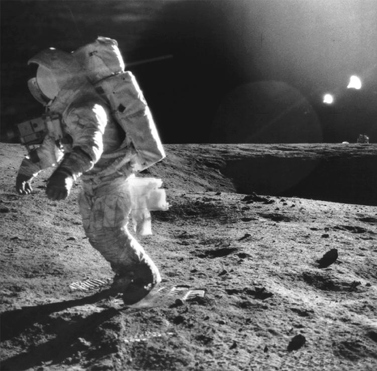 Exploring space 3 (a) The photograph shows an Apollo 12 astronaut walking on the Moon. Complete the sentence by putting a cross ( ) in the box next to your answer.