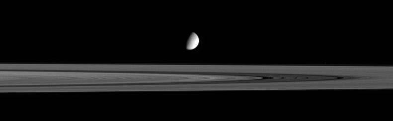Here we see Enceladus hovering past the B Ring, with 4 faint bands