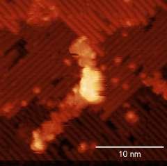 In (b) the same graphene nanoribbon appears semitransparent, with the corrugation of the silicon dimer rows visible underneath the graphene nanoribbon.