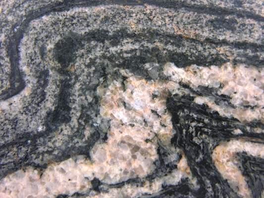 Foliated Metamorphic Rocks Migmatite is a partially melted gneiss. It has features of igneous and metamorphic rocks. Mineralogy controls behavior.
