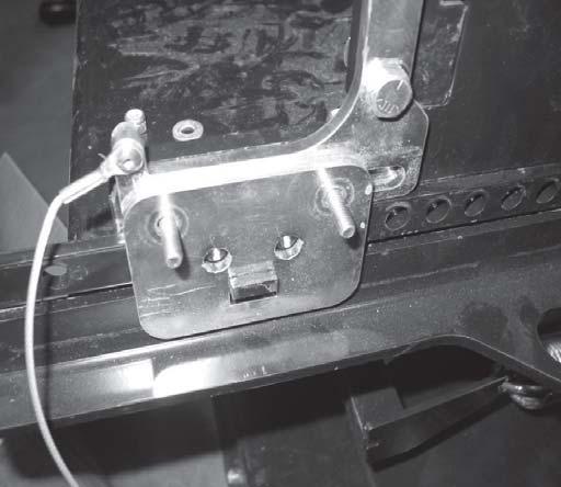 34. Install retainer plate slot over tab on plow support and push down to engage tab.