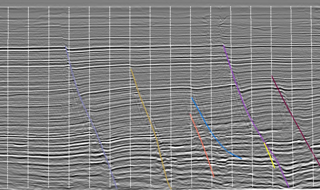 Interpreted faults are displayed as sub-vertical colored polylines.