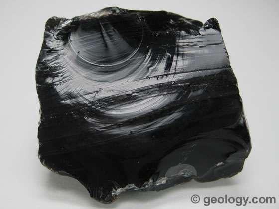 Obsidian is a dark-colored volcanic glass that forms from the very rapid cooling of molten rock material.