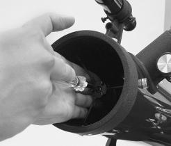 a. Figure 7. To center the secondary mirror under the focuser, hold the secondary in place with your fingers while adjusting the primary screw with a Phillips head screwdriver.