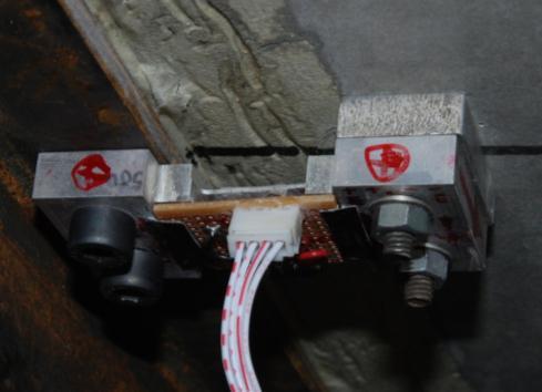 Four relative displacement sensors were fabricated and mounted on the bridge model. Figure 2 shows a developed relative displacement sensor prototype installed on the bridge.