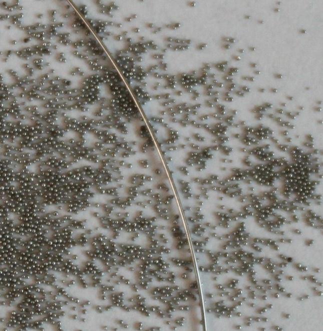 43 Figure 6-5. Photograph of 0.2 mm diameter stainless steel spheres (shown with 0.254 mm wire). 6.2. Experiment in Air The objective of the experiment performed in air is to show that effective thermal conductivity is an anisotropic property of granular beds.