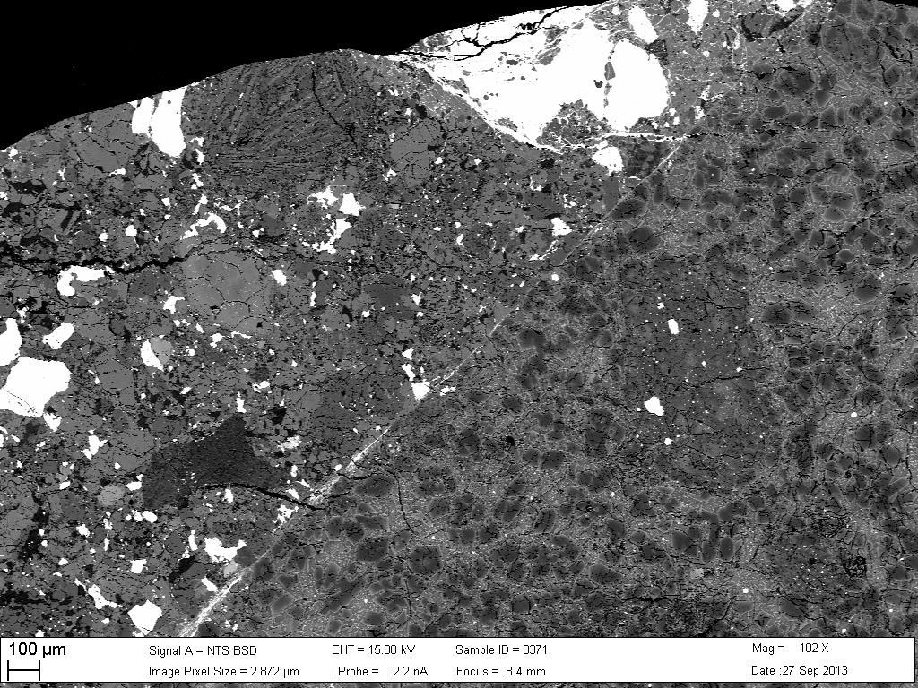 Figure 8: Backscattered Electron (BSE) image showing contact between zoned olivine grains in the melt region (lower right) and unmelted chondritic host (upper left).