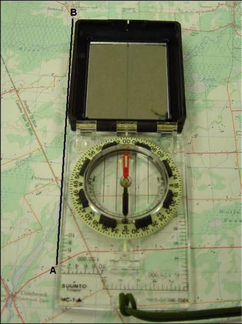 Hold the compass at eye level, at arms length, and face the prominent object. 3. Aim at the object using the compass sight, ensuring the sighting line is in line with the index pointer. 4.