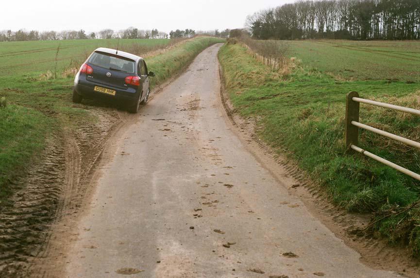 52. Damaged roadside verges and soil on road,