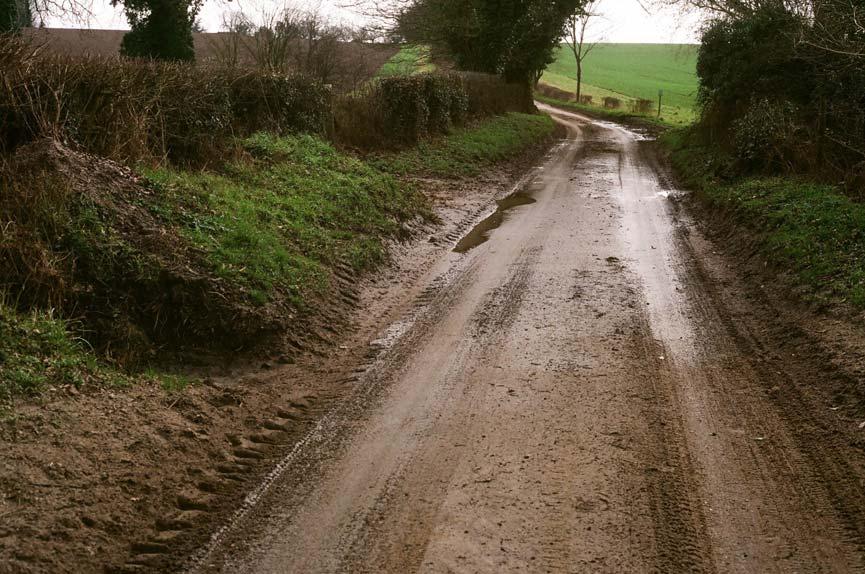 Damaged roadside verges and soil on road, valley