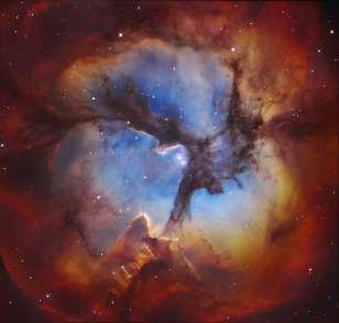 surrounded by an emission nebula, a reflection nebula, and a dark nebula within the emission nebula that gives it the