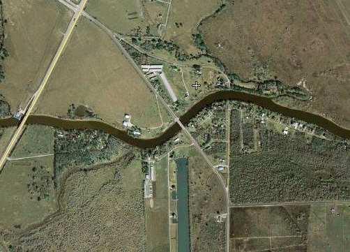 4 A satellite photo tells the story: a new bridge carries the highway (FM 523) across the bayou, bypassing the community. But the approach roads to the old bridge stand out clearly.