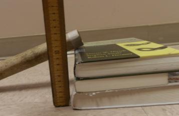 6. Lean a grooved ruler or paper towel tube against the textbooks (or other props) so that the top end is at the 5 cm height while the other end is
