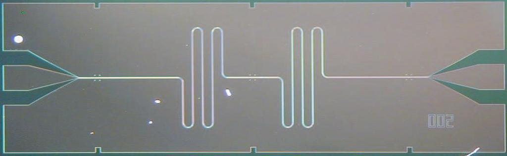 2 A mm B 5 µm 5 µm FIG. : Integrated circuit for cavity QED. a The superconducting niobium coplanar waveguide resonator is fabricated on an oxidized 3 mm 2 silicon chip using optical lithography.