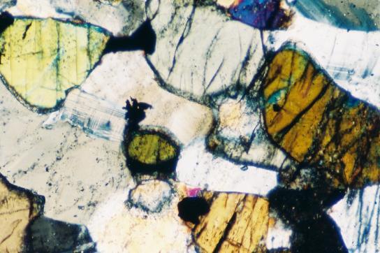 twisted and altered along the weak planes. Tabular to lath shaped biotite grains are highly altered, fractured and iron leached. (Fig.