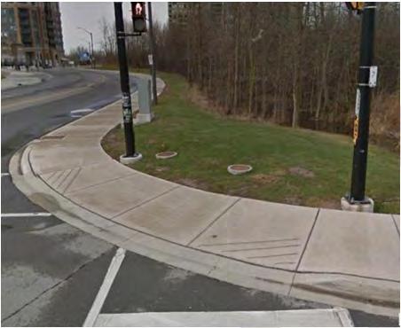 Contrast paving (concrete) is present on east leg of intersection; pedestrian signals and push buttons on all corners.