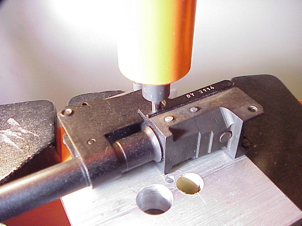 2. With the barrel supported and trunnion aligned; insert the short push rod (a hardened screwdriver hex bit may be used to start the removal) on the center barrel pin.