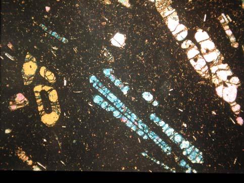 crystals Example: euhedral to subhedral biotite and plagioclase crystals are surrounded by optically-continuous, gray-colored K-feldspar.