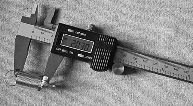 3 A student uses a digital calliper to measure the length of a spring, as shown in Figure 5. Figure 5 The spring is bendy and difficult to measure.