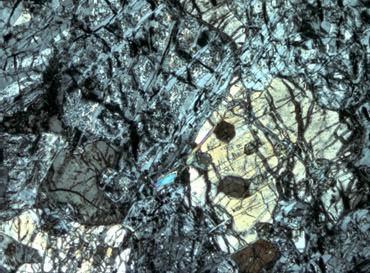 a) serpentine b) olivine olivine relict oxide biotite Fig. 5.6: Serpentinized peridotite (a and b) Relict, partially serpentinised olivine and orthopyroxene, sample MO 26.